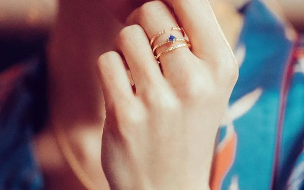 Bague saphir bleu et diamants en or jaune 18 carats portée à la main par Mayuri
