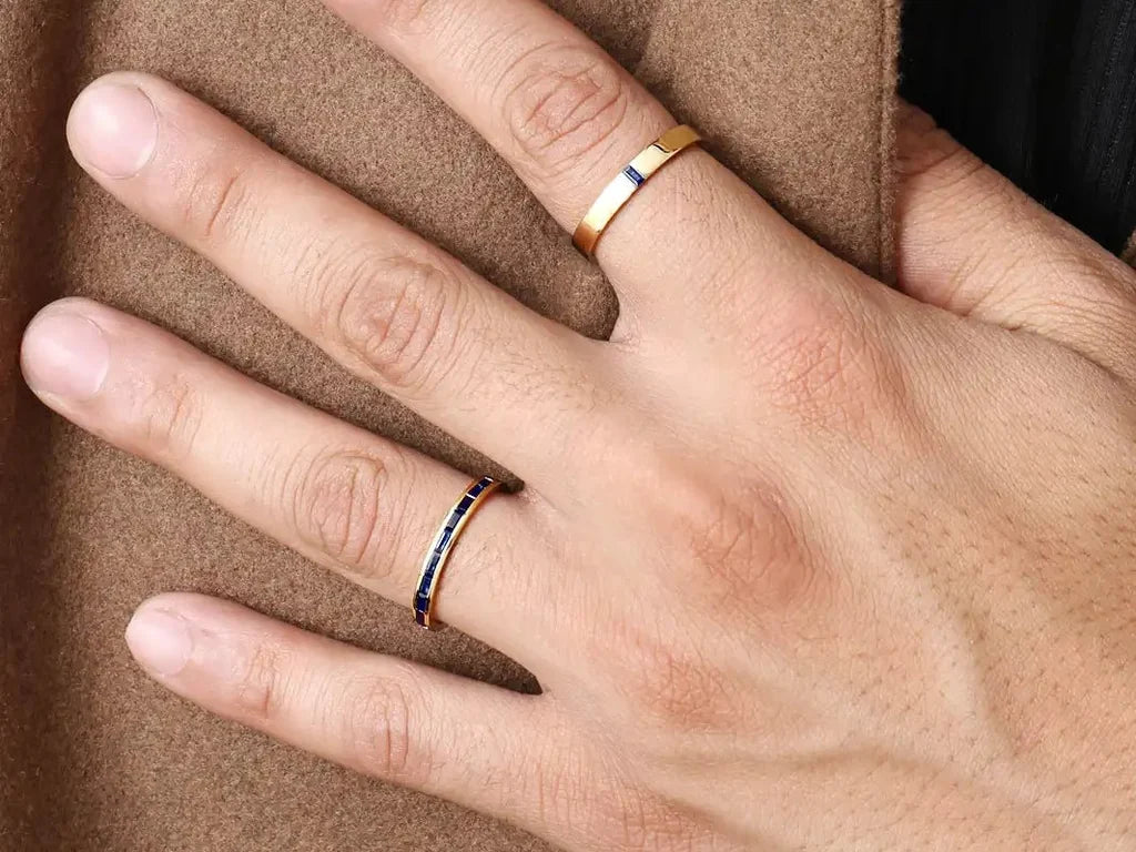 Deux bagues de fiançailles homme Mayuri en or jaune 18 carats serties de saphirs, portées à la main