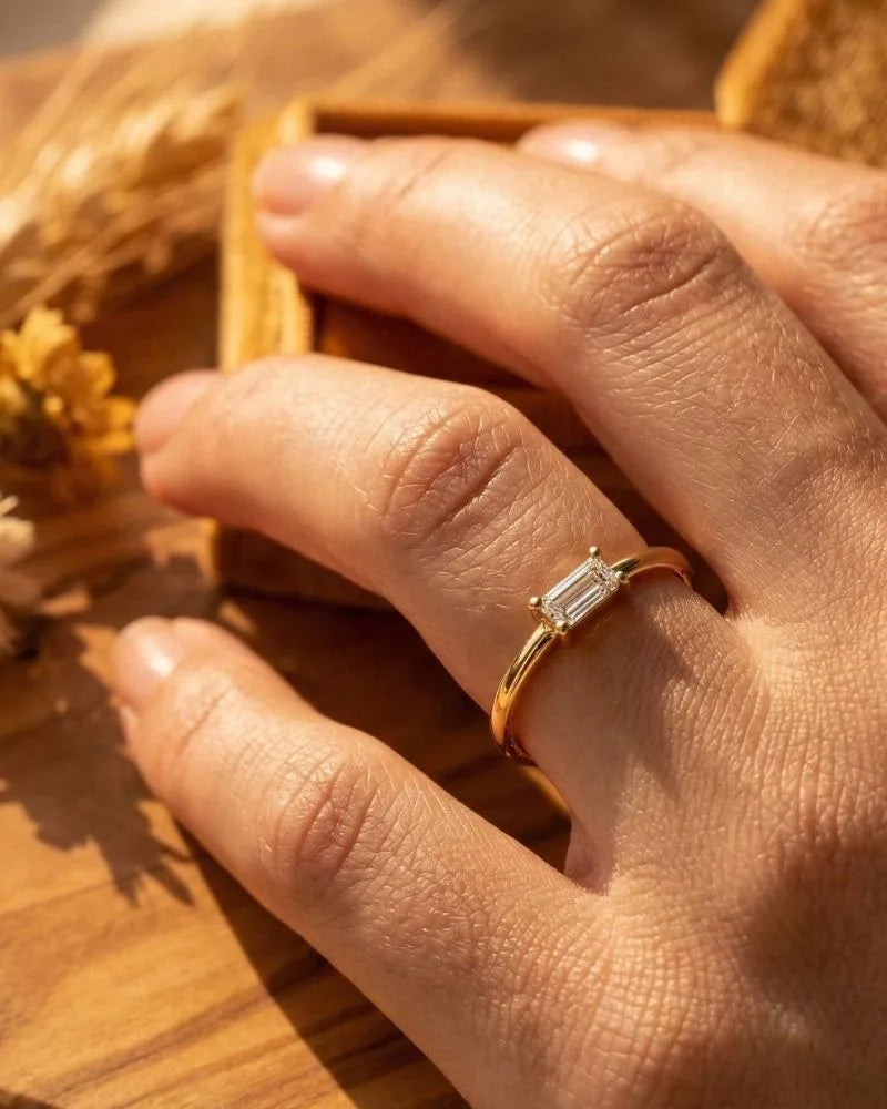 Bague solitaire en or jaune 18 carats portée au doigt, symbole de promesse et d'engagement par Mayuri