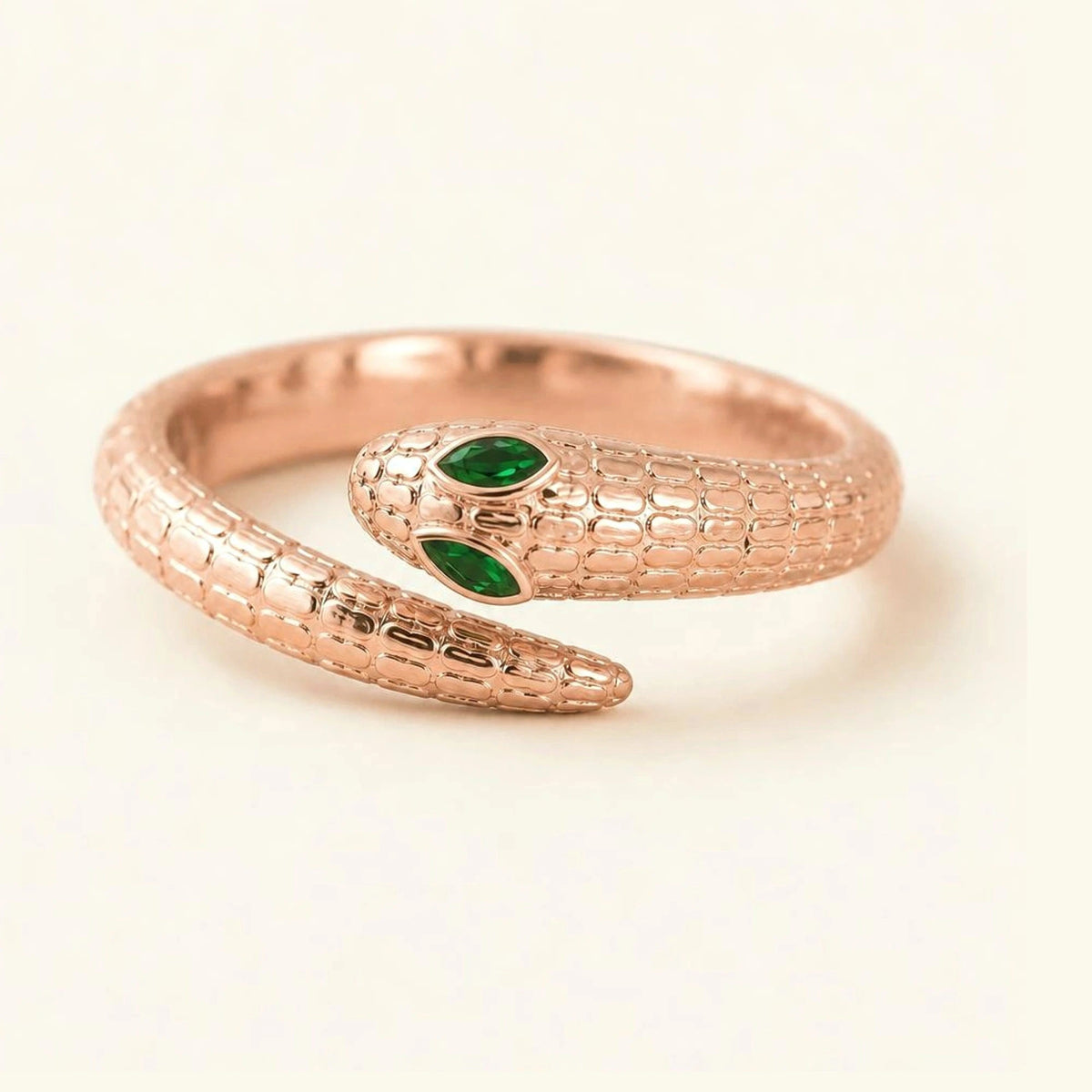 Bague serpent Méhen en or rose 18 carats, corps écaillé et yeux en émeraude marquise