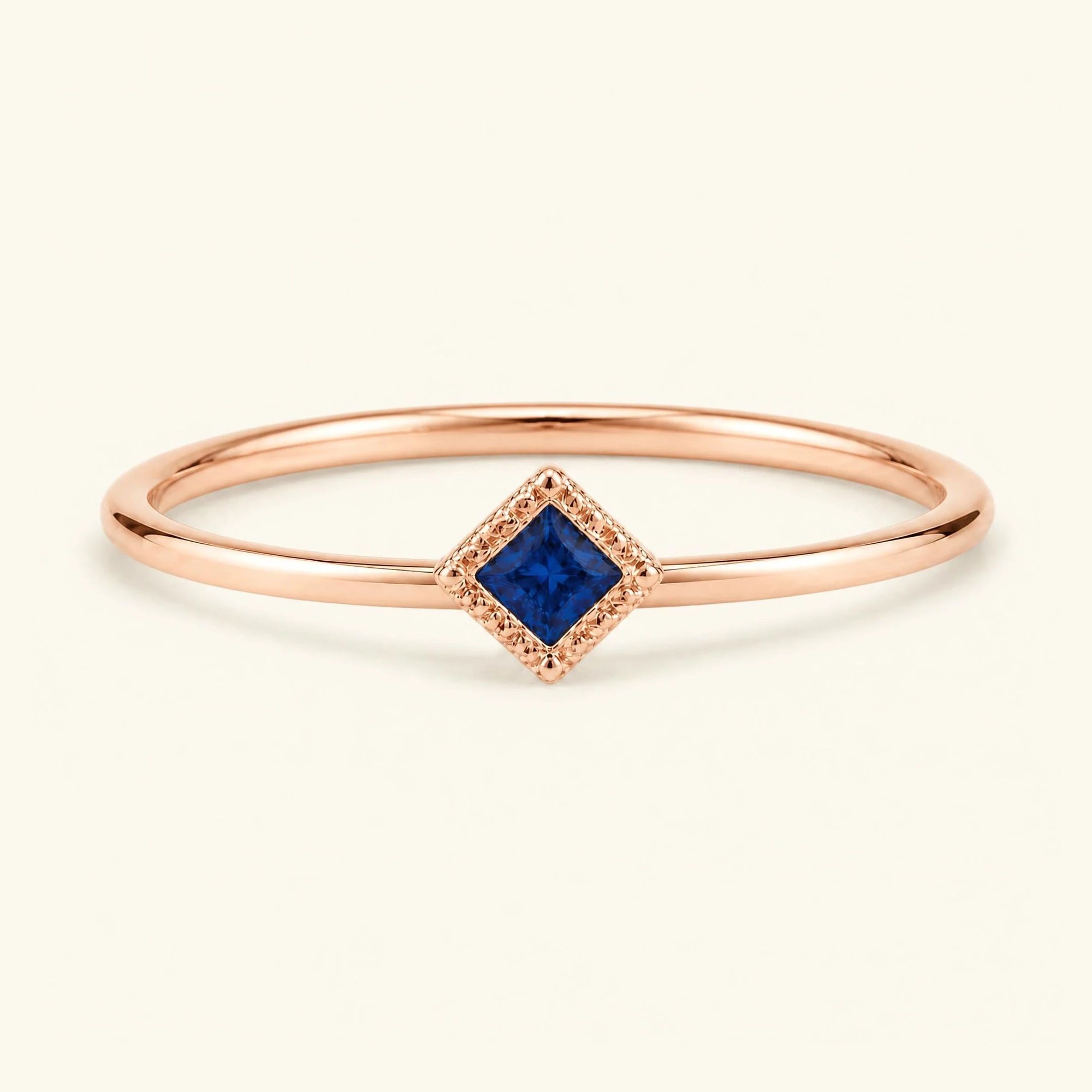 Bague de fiançailles vintage Indrani — solitaire saphir taille princesse 4 mm, pierre carrée sertie grènetis (milgrain), en or rose 18 carats
