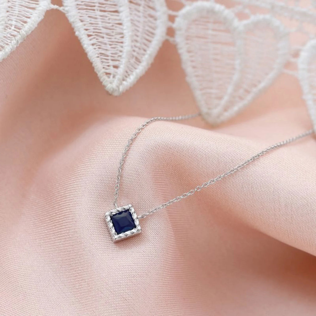 Collier en or blanc et saphir sur peau à sous-ton froid, alliance lumineuse