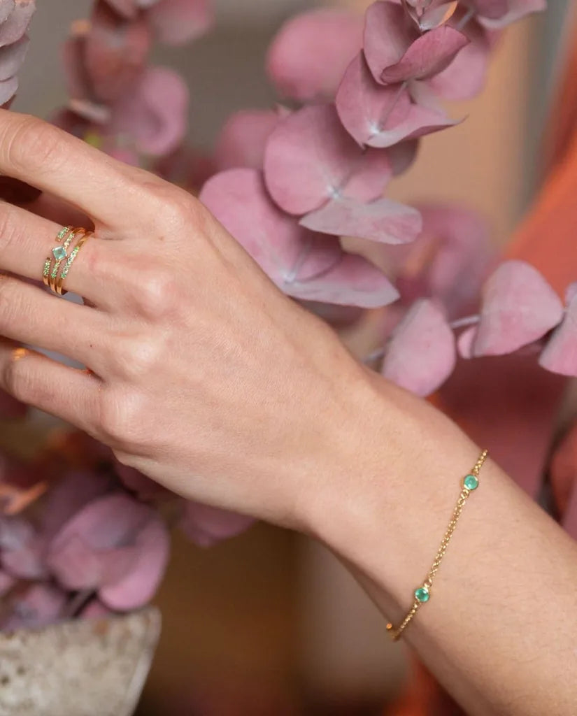 Bracelet Dhanya en émeraude et or jaune porté au poignet, idée de cadeau de témoin de mariage
