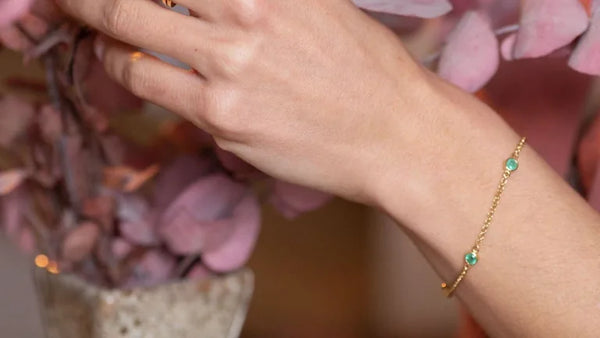 Bracelet Dhanya en émeraude et or jaune porté au poignet, idée de cadeau de témoin de mariage
