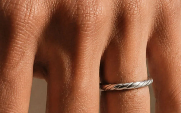 Alliance torsadée Vasuki en or blanc 18 carats portée au doigt, illustrant le guide de la taille de bague