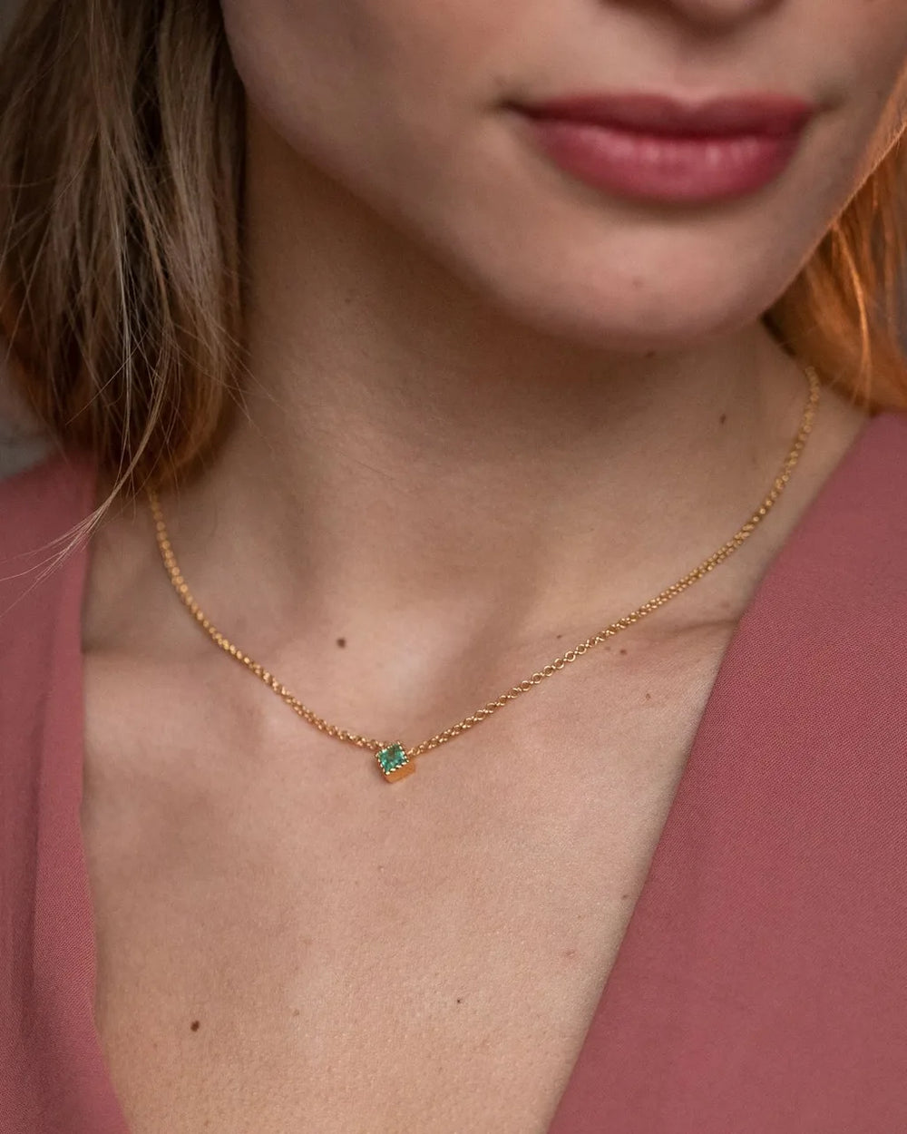 Collier Indrani en or jaune 18 carats avec émeraude et chaîne fine portée au cou par Mayuri