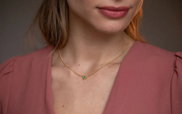 Collier Indrani en or jaune 18 carats avec émeraude et chaîne fine portée au cou par Mayuri