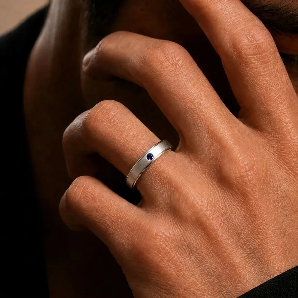 Jonc en or blanc 18 carats serti d'un saphir bleu porté au doigt par Mayuri