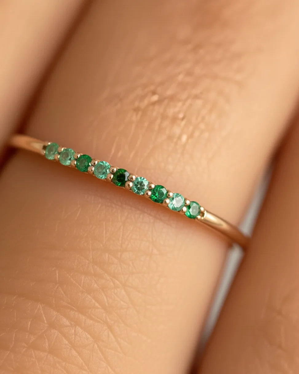 Bague Kiran en or blanc sertie d'un dégradé d'émeraudes et tsavorites, gros plan sur les pierres vertes