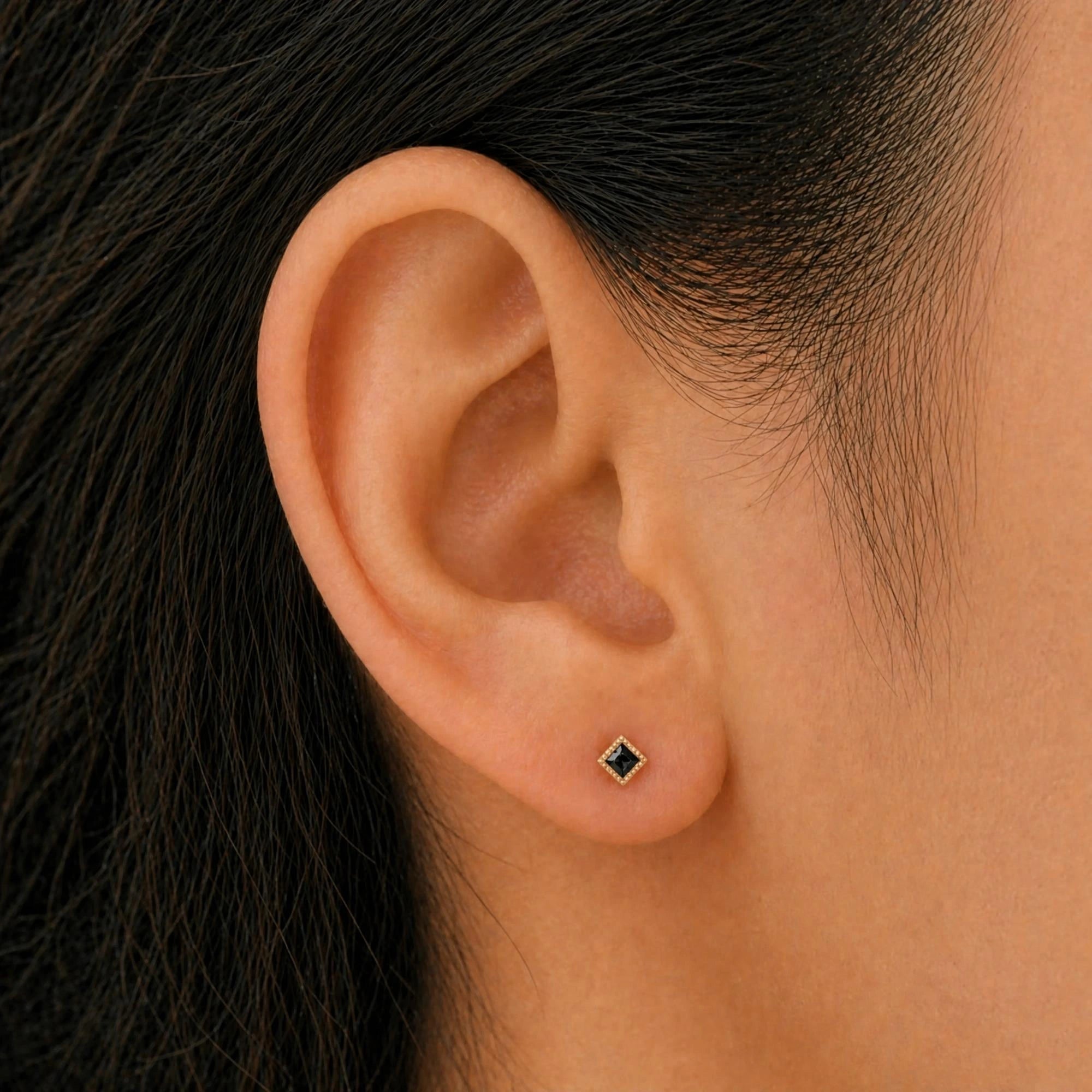 Boucles d'oreilles Indrani diamant noir portées à l'oreille, puce princesse sertie torsade en or jaune