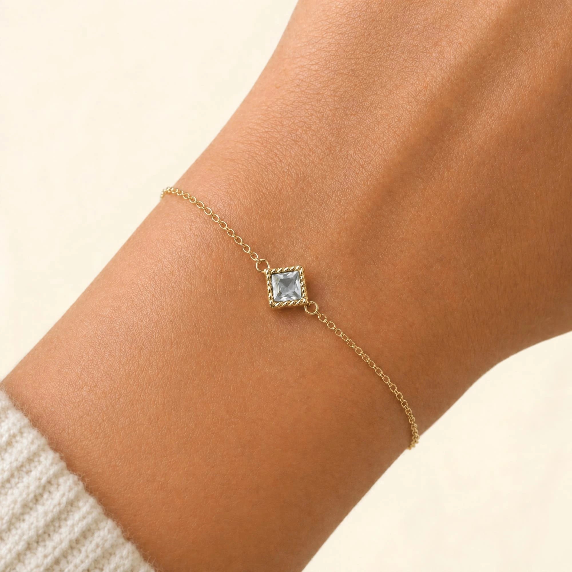 Bracelet diamant Indrani porté au poignet, solitaire princesse serti torsade en or jaune 18 carats