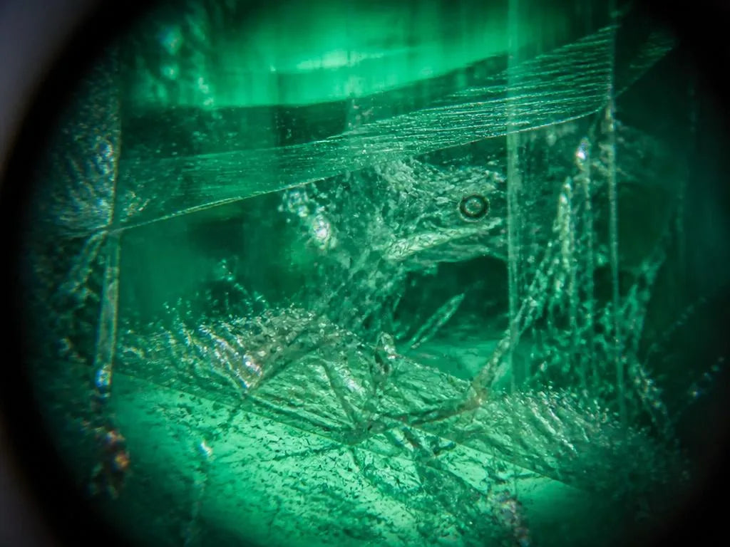 Vue à la loupe des inclusions jardin caractéristiques à l'intérieur d'une émeraude naturelle non traitée