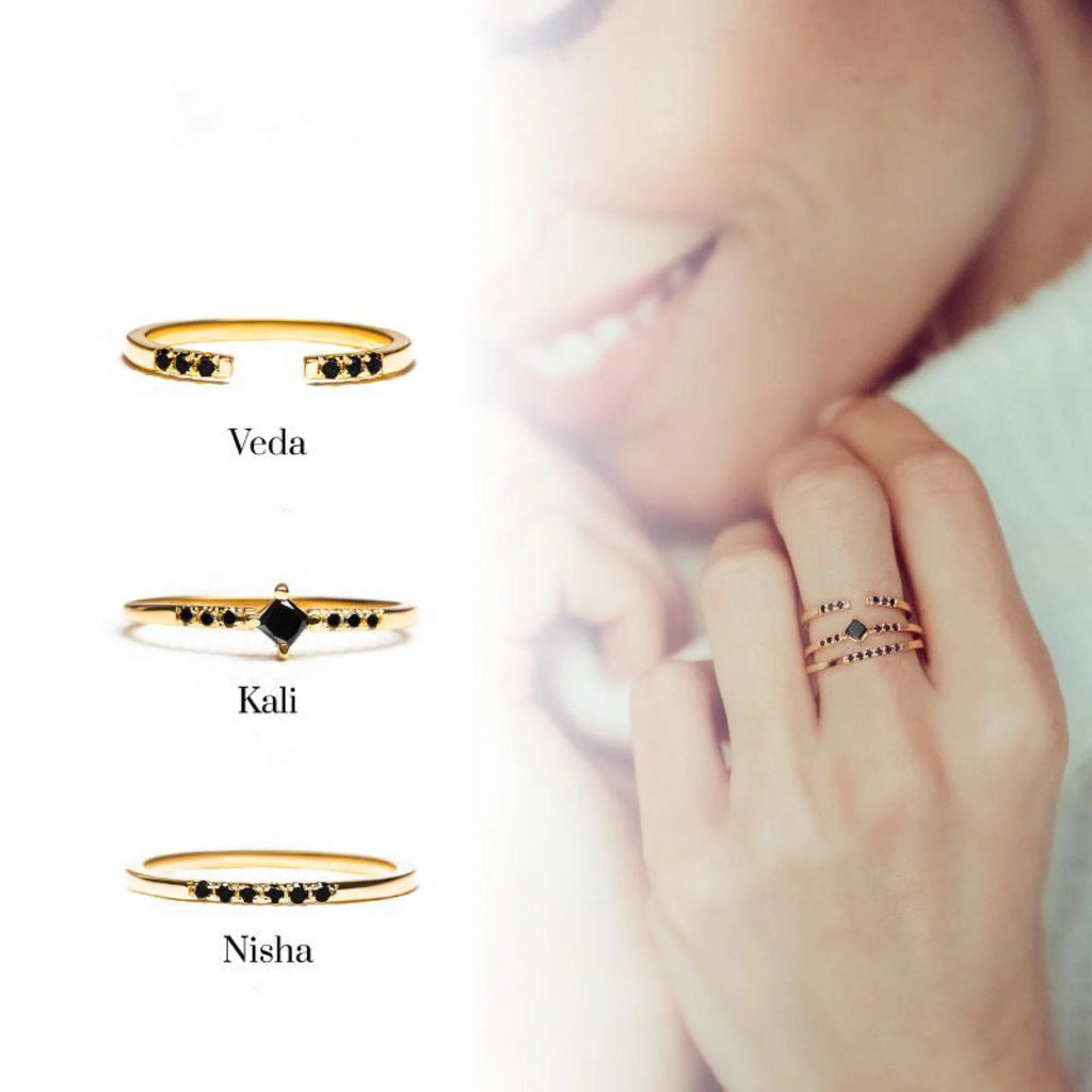 Superposition de bagues en or jaune et diamant noir, illustration du stacking contemporain